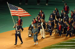 Kevin Szott leads Team USA onto the field carrying the American flag in the opening ceremonies.